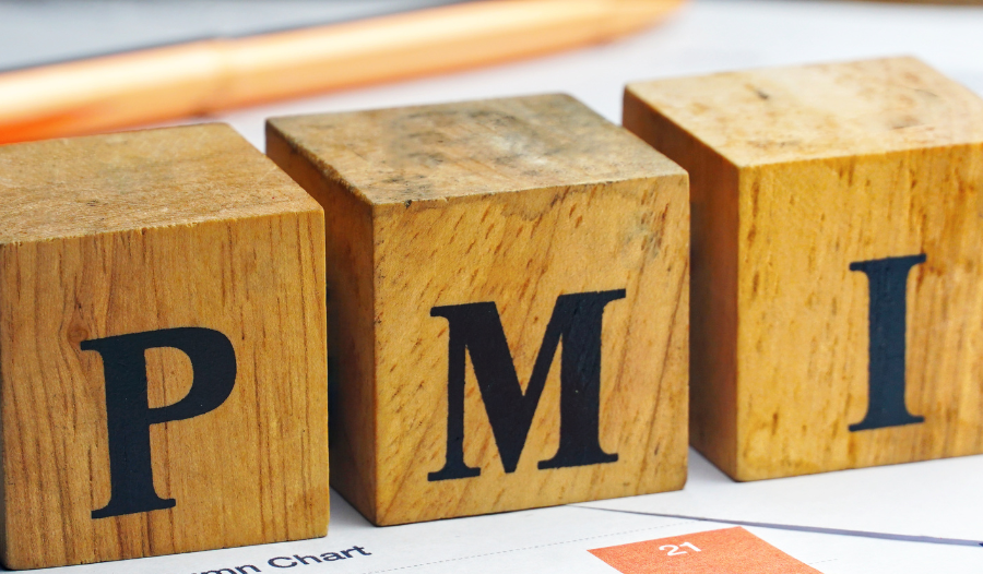 Wooden blocks spelling PMI on top of financial bar charts